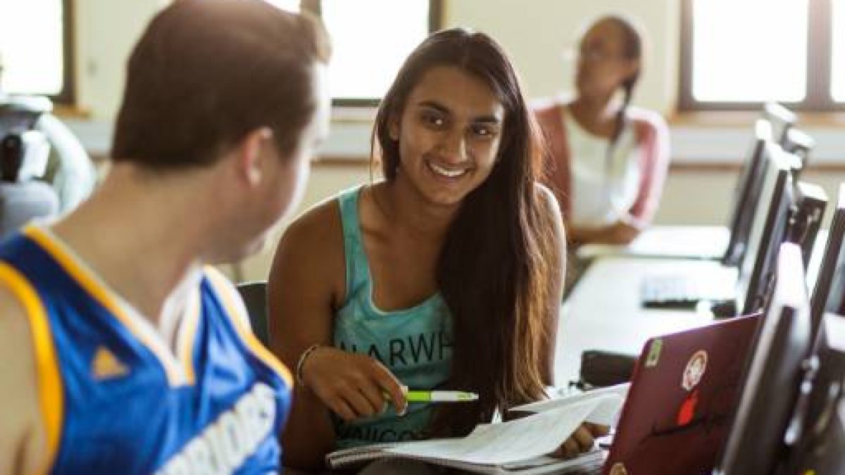 student smiling at another student in a classroom