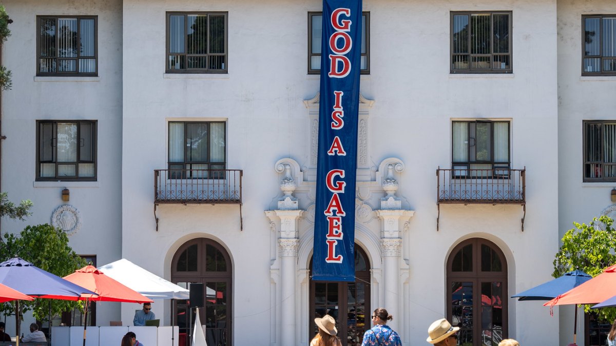 A banner hangs from the three-story dorm reading "God is a Gael"