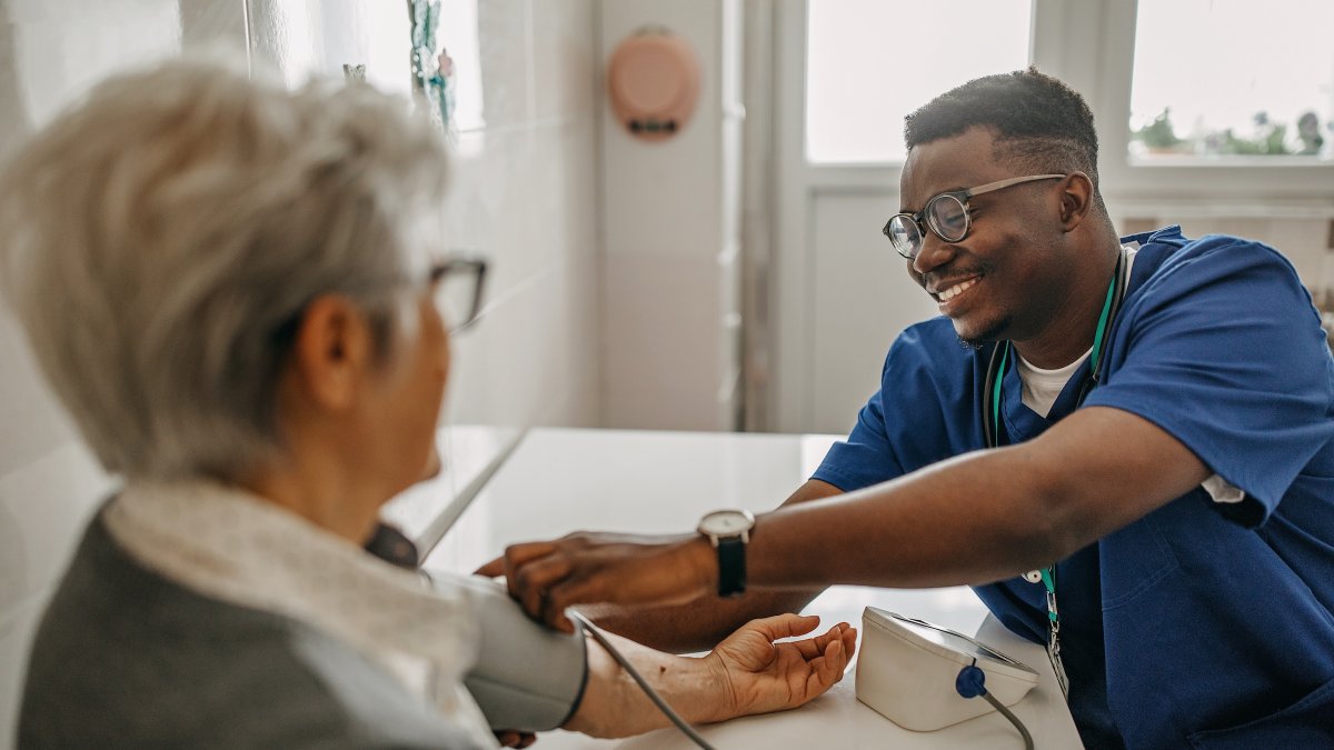 A nurse taking a woman's blood pressure